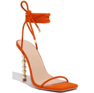 Orange strappy tie up heel with gold stiletto.